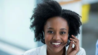 Eine Frau mit Headset nimmt einen Hotline-Anruf entgegen.