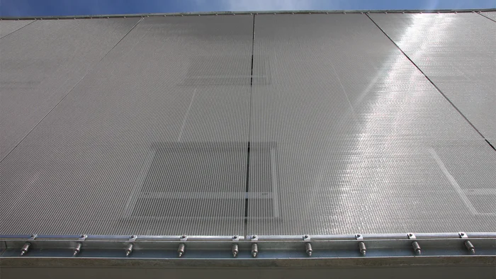 Facade cladding with metal mesh sun protection mesh