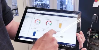 Ein Tablet zeigt aktuelle Maschinendaten, die durch QUAT2RO® Monitoring.