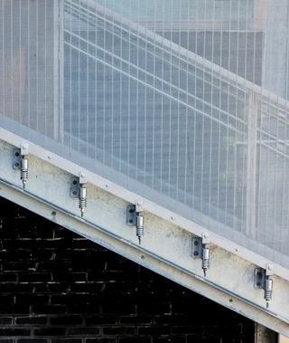 Fastening system for façade cladding consisting of a flat tensioning edge, clevis screw and compression springs.