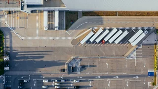 Der Außenbereich einer verladezone mit LKWs aus der Vogelperspektive.