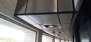 Modern wall and ceiling covering made out of stainless steel wire mesh with integrated ceiling lighting.