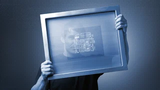 Man holding metal frame with screen-printed wire mesh and circuit board pattern, symbolizing Haver & Boecker's precision wire mesh for technical applications.