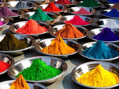 Multiple containers filled with various pigment powders — ideal candidates for hybrid FFS packing using HAVER & BOECKER ADAMS® technology