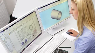 Mitarbeiterin bearbeitet am PC eine Konstruktionszeichnung