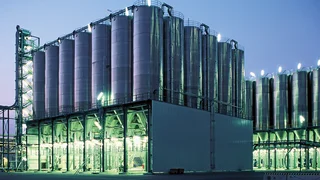 Beleuchtete großindustrielle Silo-Anlage zur Abenddämmerung.