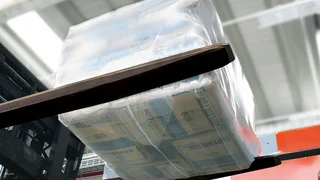 Ein palettenloser Stapel mit Zementsäcken wird vom Palettierer abtransportiert.