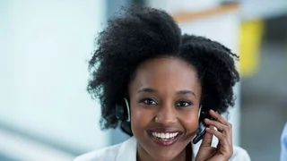 Woman with a headset answering a hotline call.