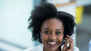 Woman with a headset answering a hotline call.
