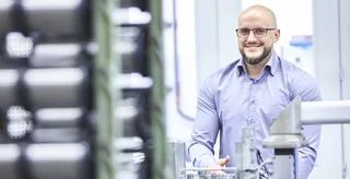 Ein Berufseinsteiger steht an seinem neuen Arbeitsplatz.