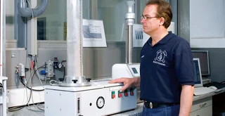 Mann misst Be- und Entlüftungsverhalten von Schüttgütern für Produkte, die kontrolliert in einen Prozess einfließen