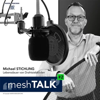 Michael Stichling im meshTALK Podcast von Haver & Boecker über Lebensdauer von Drahtsiebböden, vor Mikrofon mit Drahtgitter in der Hand.